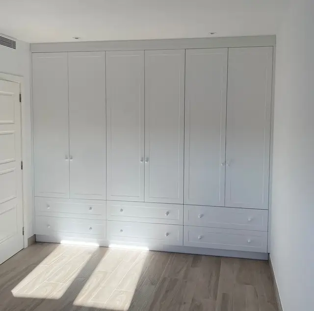 Armario empotrado blanco con puertas y cajones, trabajo de Dos Ambients