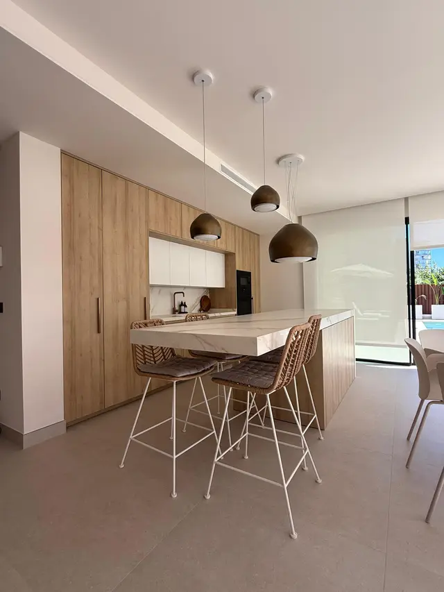 Cocina en madera con isla y lámparas colgantes, trabajo de Dos Ambients