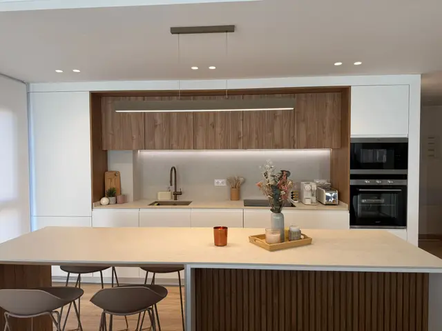 Cocina con isla, frentes blancos y madera, trabajo de Dos Ambients