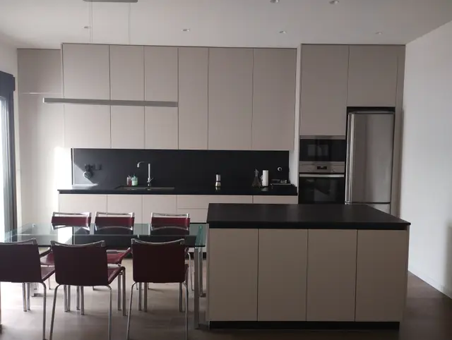 Cocina con isla y frentes lisos sin tiradores, trabajo de Dos Ambients